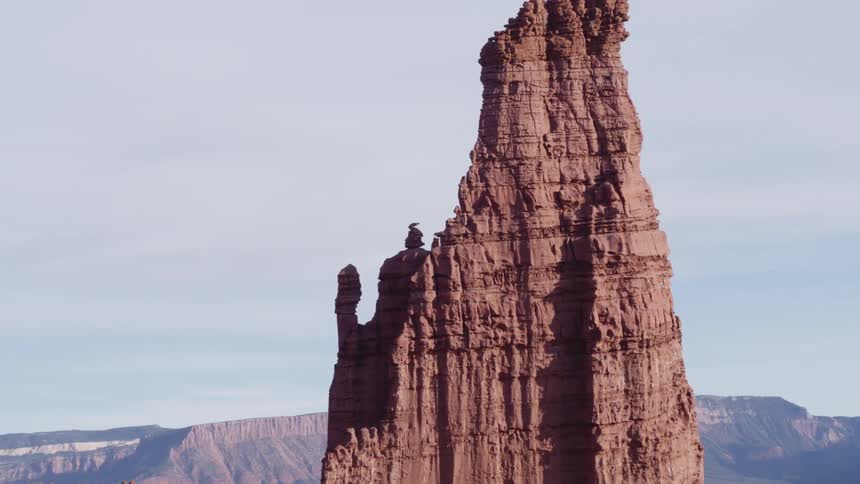 A tall rock formation rises above the fog