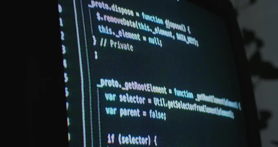 The monitor is scrolling computer code