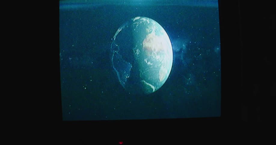 Planet earth rotating on the television screen inside a dark room