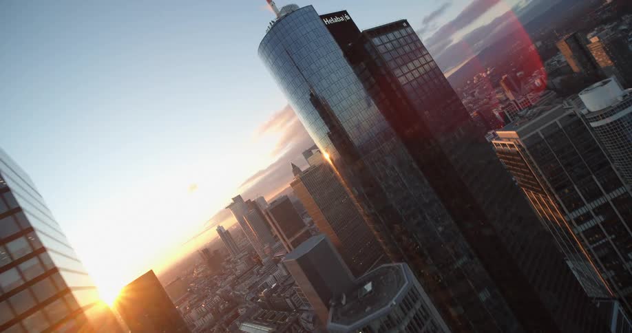 Sun sitting on horizon creates sun glare back lighting skyscrapers downtown