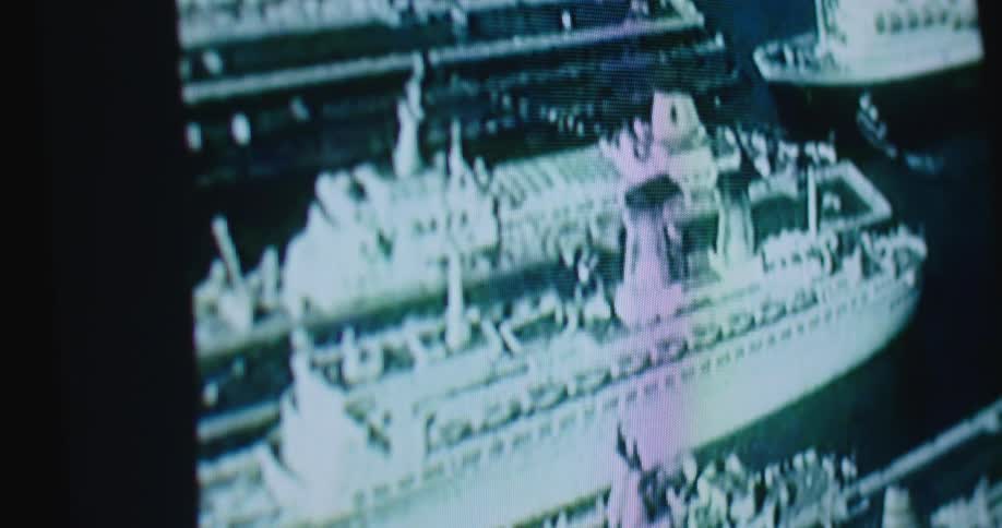 A television with the statue of liberty and boats in the water on the screen