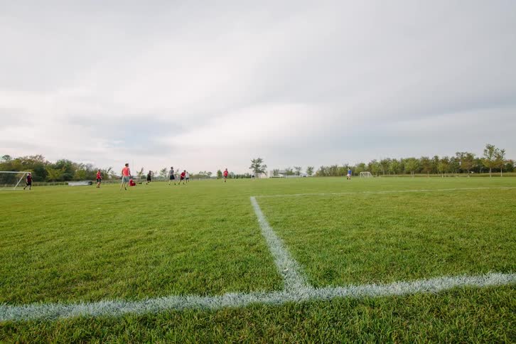 Soccer players run around on the field