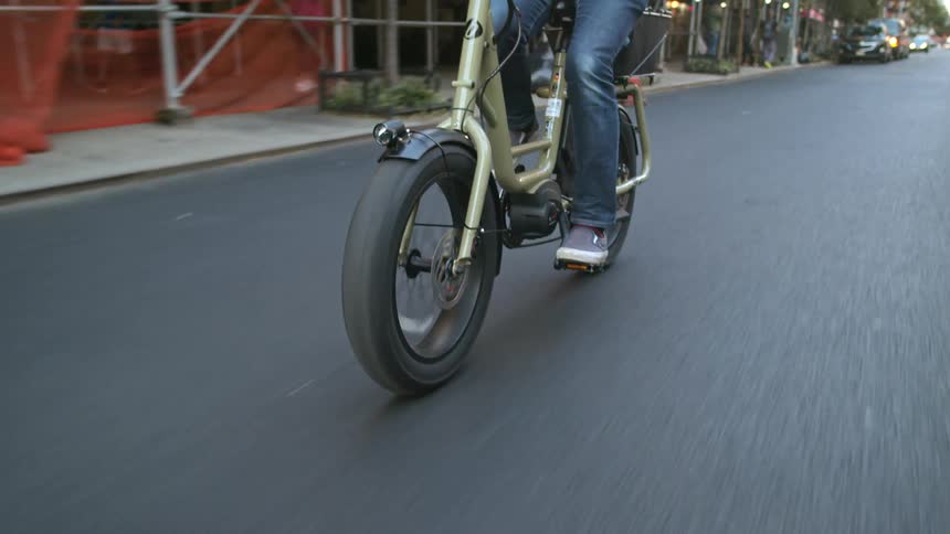 Person rides a bicycle on the road of a city at morning