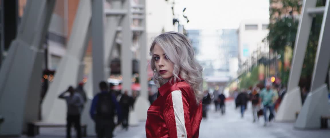 A model turns around on the sidewalk in the city