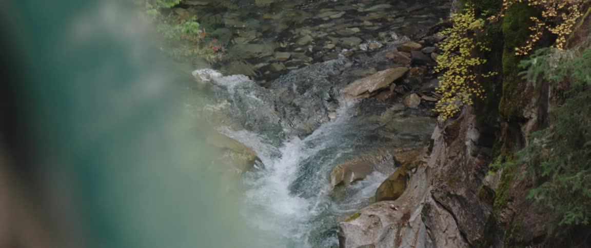 River water flows over rocks and stones down a slope