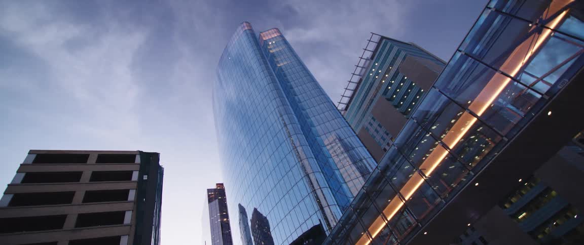 Glass facade of a tall skyscraper in the city skyline at morning