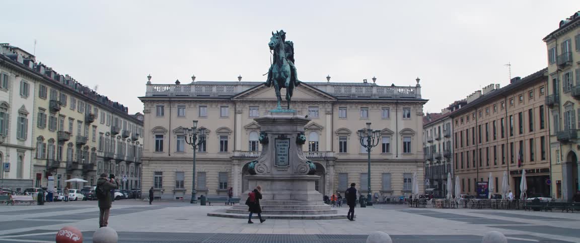 Tourists walk past the statue in the monument
