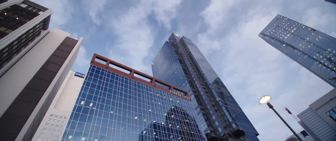 Glass facade of tall skyscrapers on the city skyline under the clouds