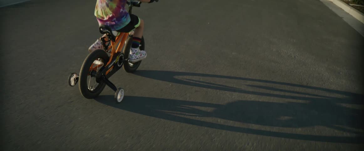 A child is riding their bike in the street