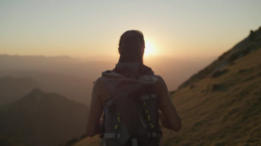 A woman is hiking outdoors at dusk