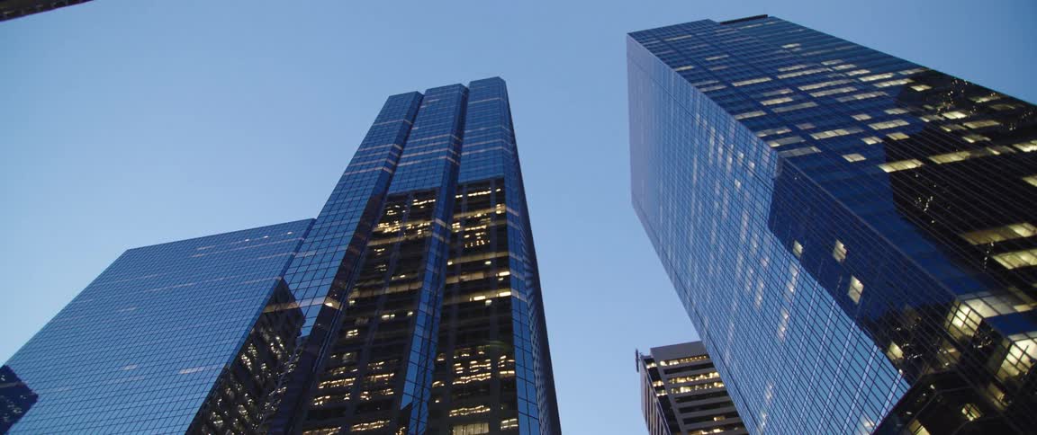 Skyscrapers reaching high in a clear sky with the lights on