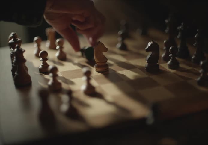 A person moves the chess piece