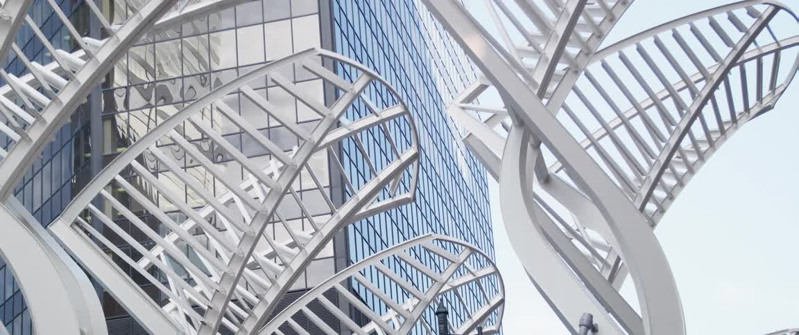 Modern white metal sculpture in front of the facade of a building in the city