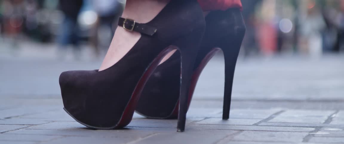 Woman standing on the street wearing shoes with platform and high heels