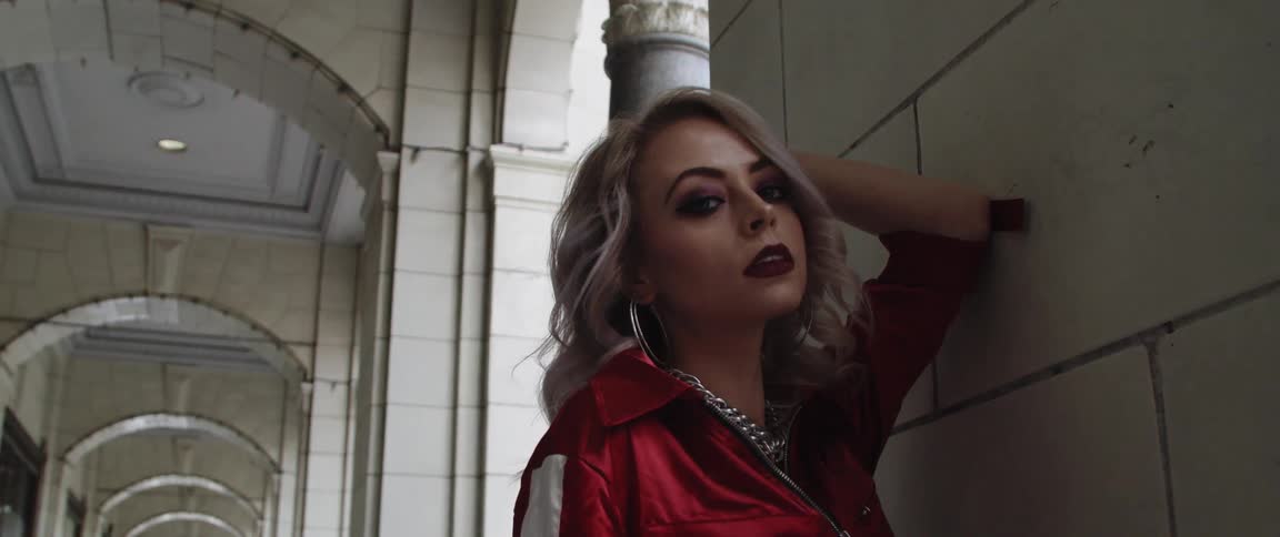 A portrait of a woman in an outdoor hallway