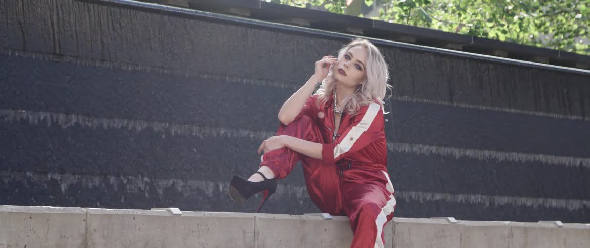 A woman is sitting by the fountain posing