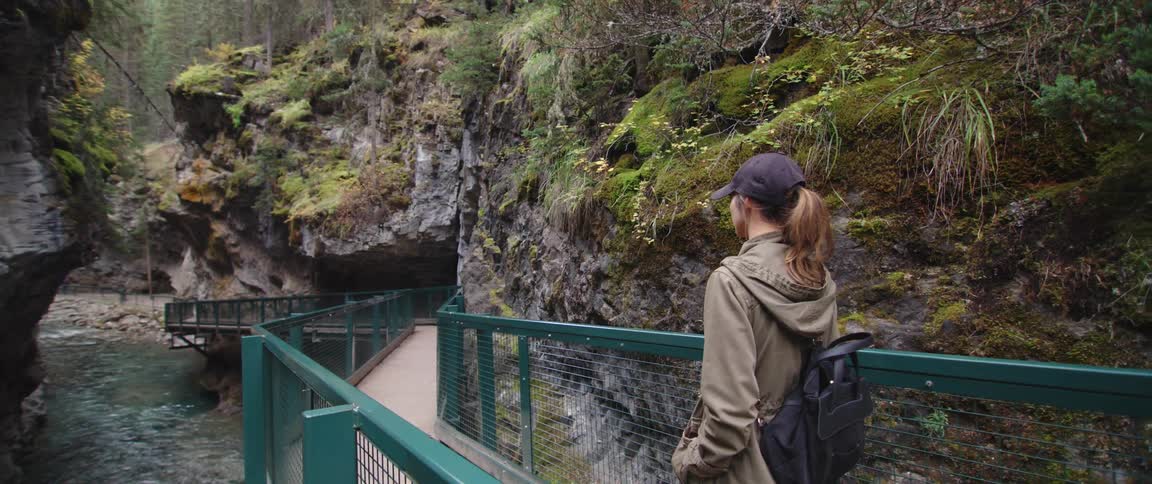 A woman is walking on a bridge over a river