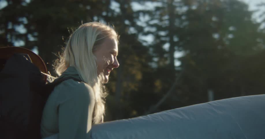 Women carry their surfboards by the forest