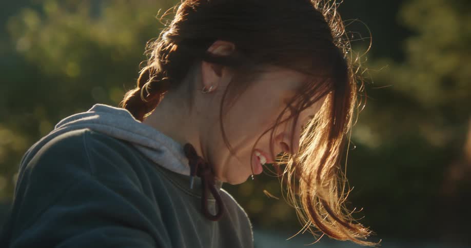 Woman smiles while friends comb hair in their background