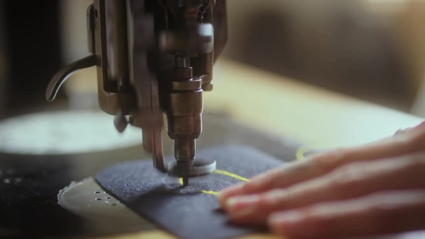 A person is using a sewing machine indoors