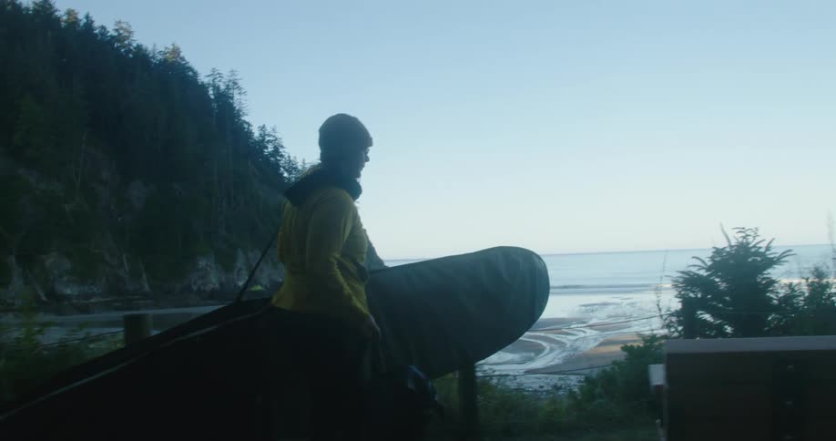 A woman carrying a surfboard to the beach