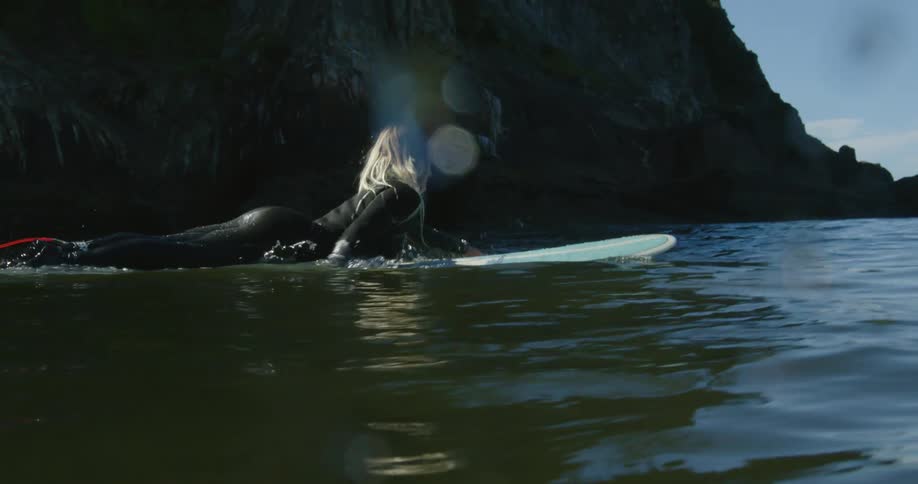 A woman is surfing on ocean water