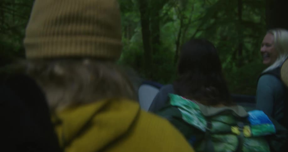 Women carry their surfboards into the forest