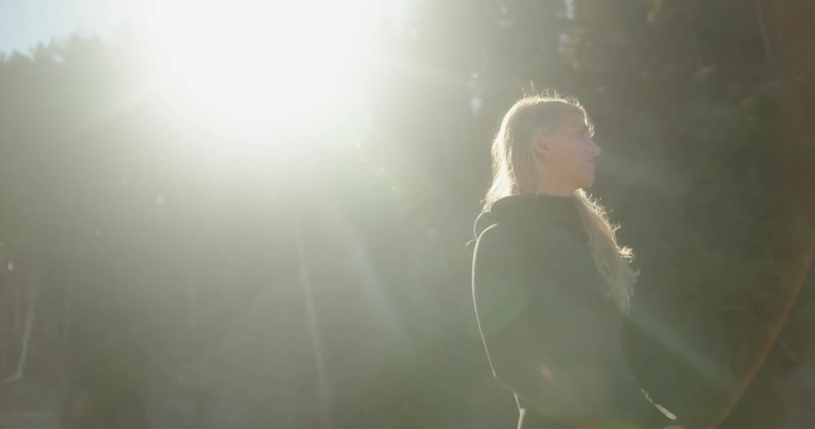 A woman is standing under the bright sun