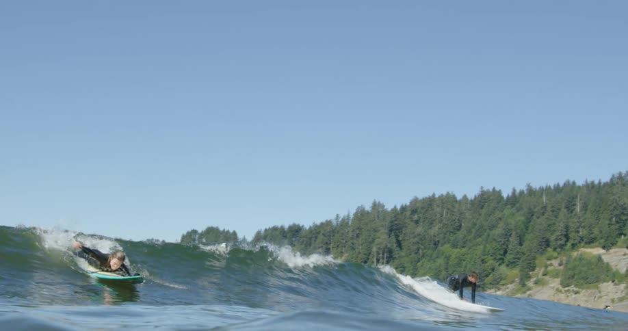 Two women surfing on waves outdoors