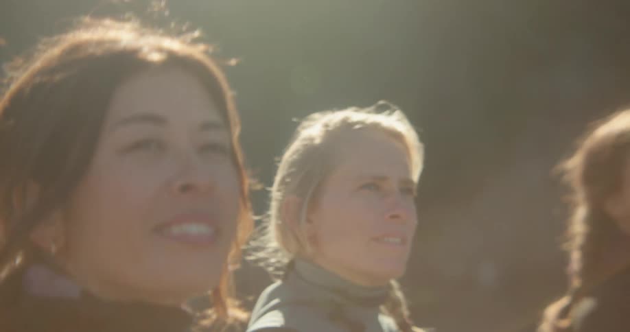 Women walk on a sunny day with their surfboards
