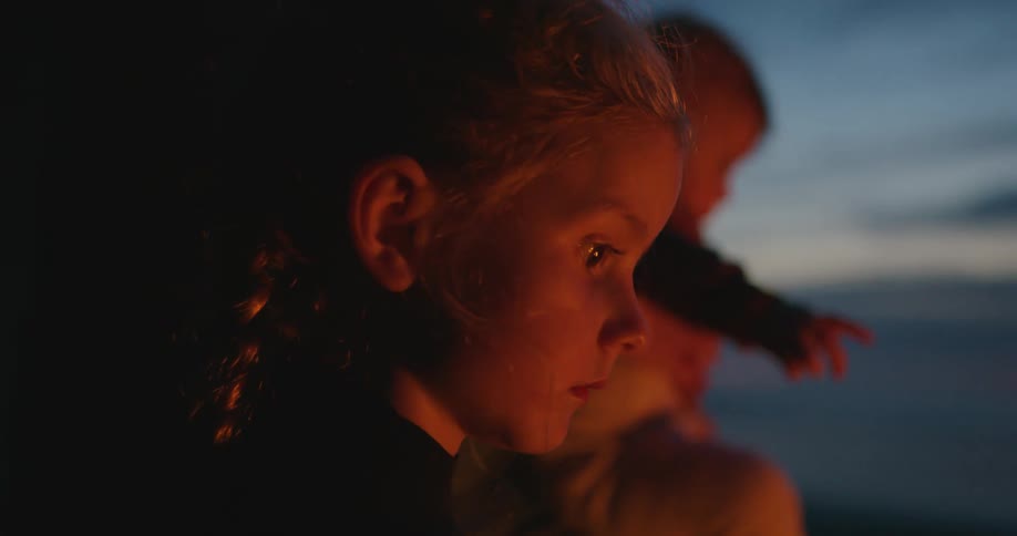 A child watches the flickering fire