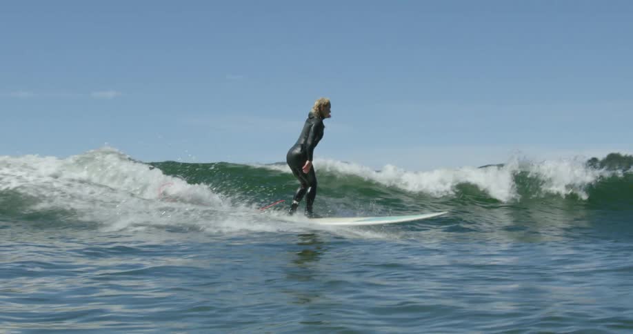 A group of people ride surfboards on a large wave together