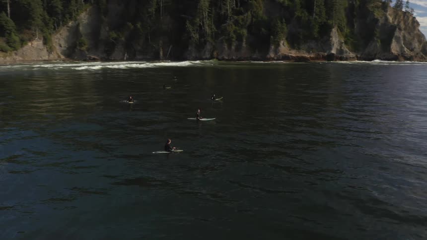 People are floating out into the sea on their surfboards