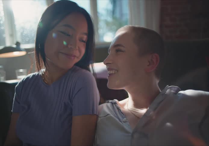 Young couple reclining on each other on the couch in the living room at home