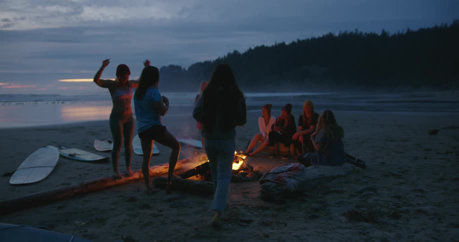 A group of people are having a bonfire at the beach