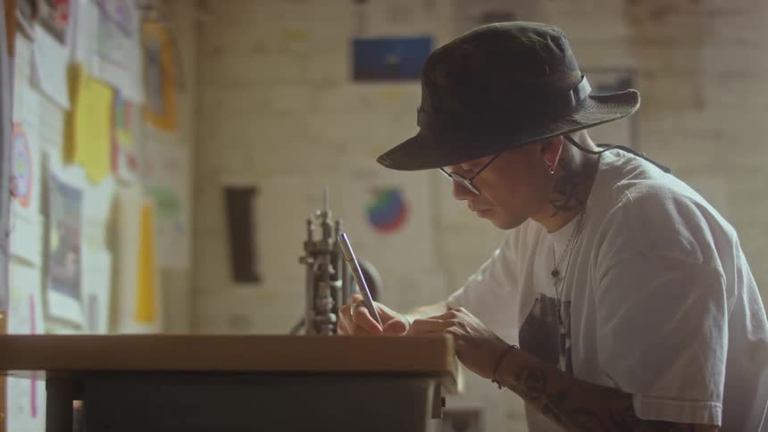 A man is writing at the desk