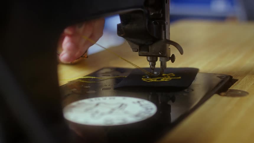 A person is adjusting the thread on the sewing machine