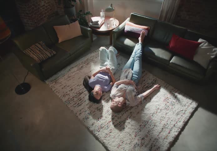Two women lay on the floor talking
