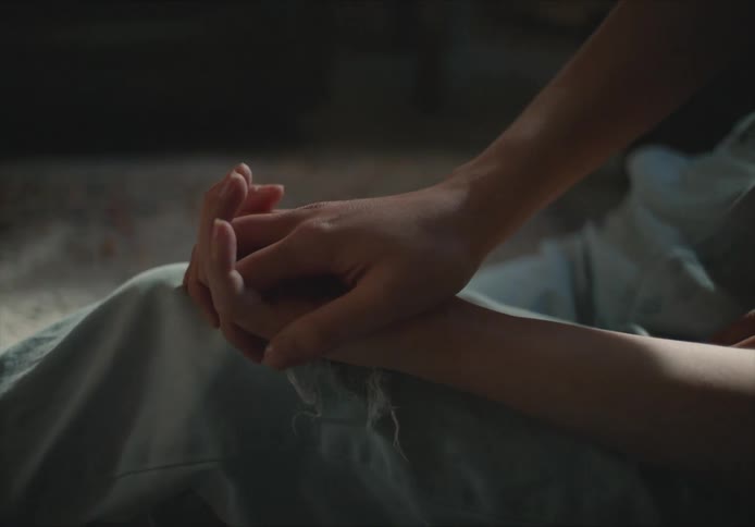 Young couple sitting on the floor on the living room holding hands