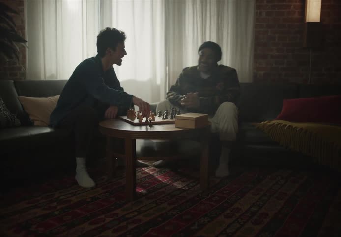 Friends playing chess in the dimly lit living room at home