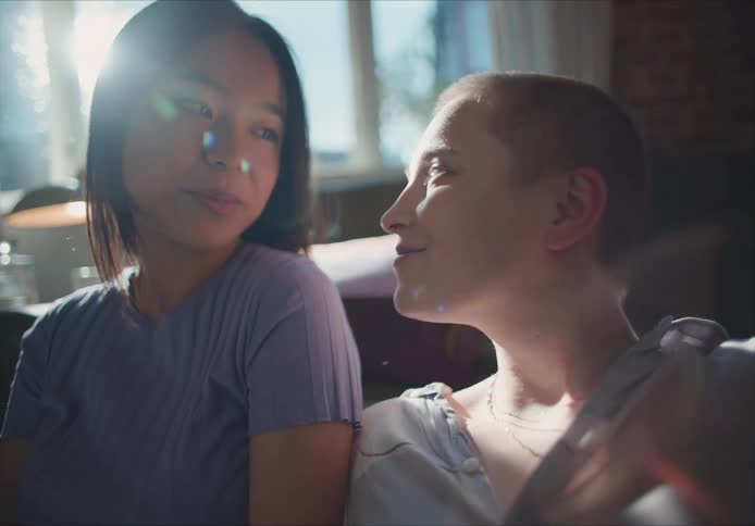 Young couple looking at each other talking and smiling in a room at home
