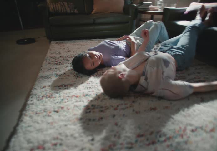 Two women lay on the floor together talking