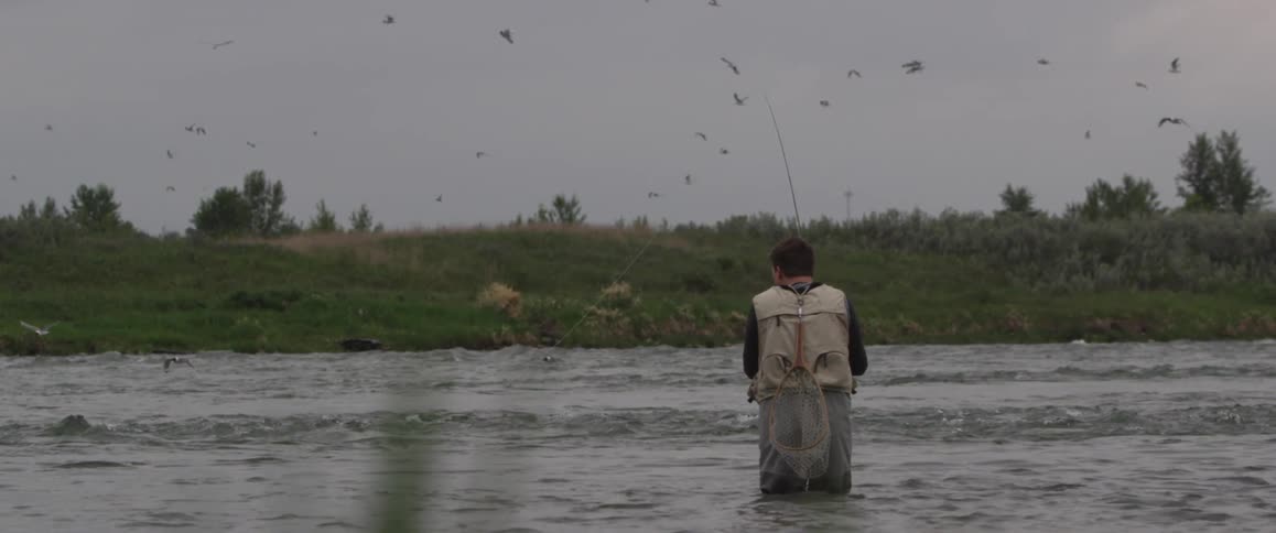 A man is fishing on a cloudy day