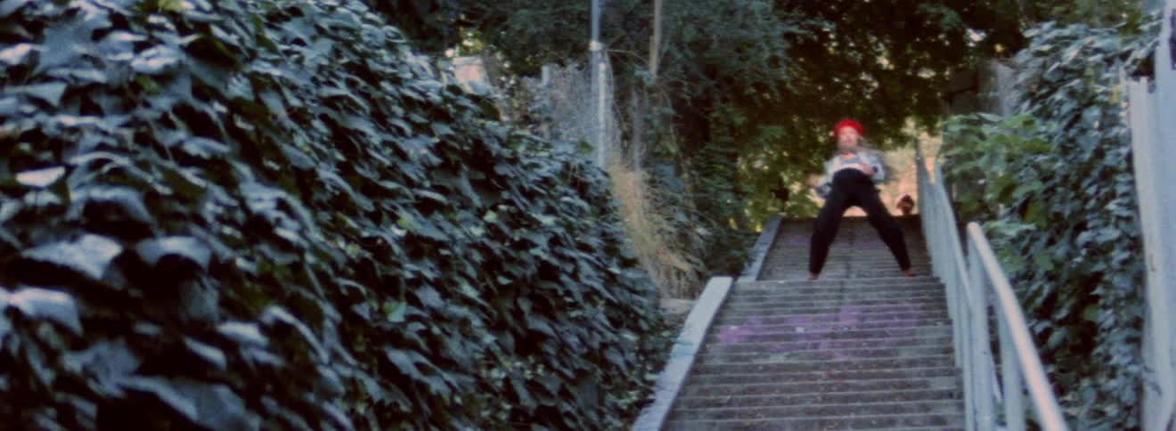 A woman is dancing on the stairwell outside