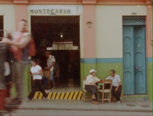 A truck carrying sandbags drives past a busy restaurant