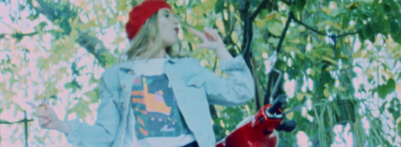 A model blows out finger guns as she poses in front of a red scooter