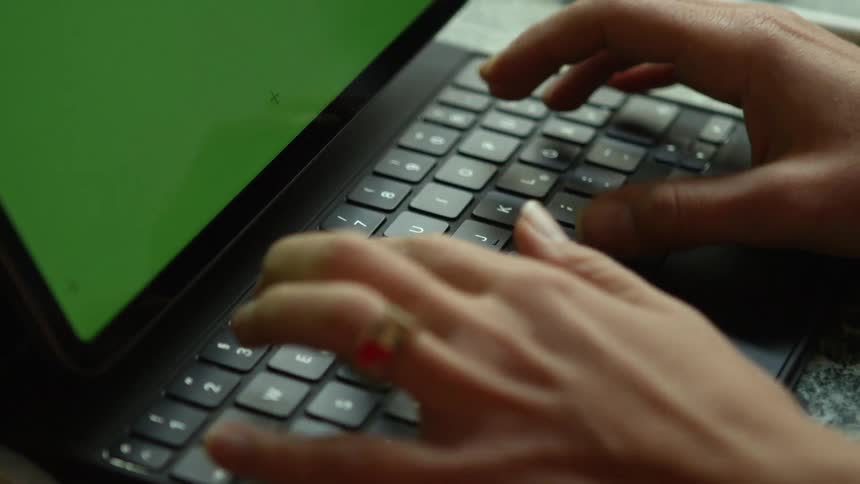 A woman is typing on a keyboard