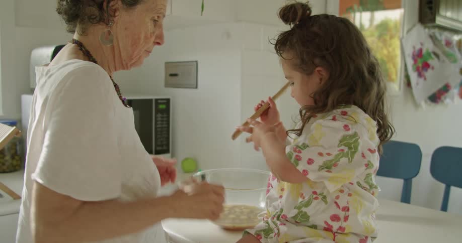 Grandmother and granddaughter cooking in the kitchen at home