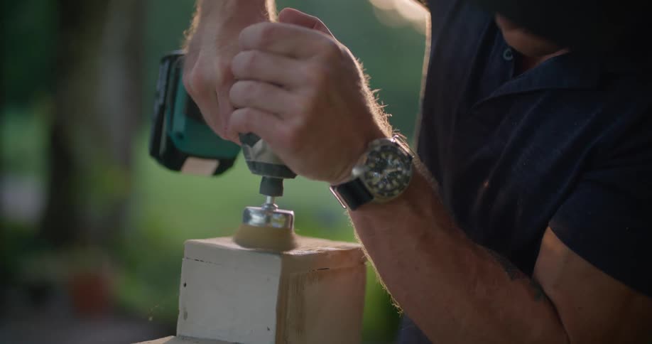 A man working on a piece of wood with a drill