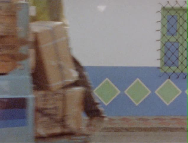 Truck passes in front of a colorful small town house caught on vintage film